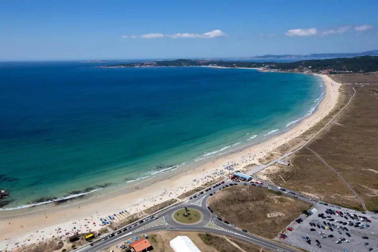 Vista aérea de la playa de A Lanzada en O Grove, con arena blanca y aguas turquesa.