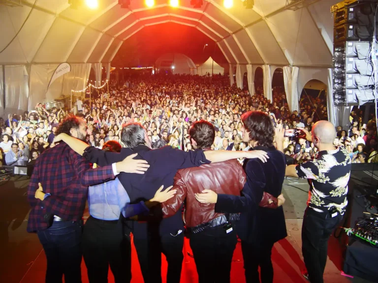 Concierto en la Fiesta del Marisco de O Grove, con un grupo saludando al público en un recinto lleno.