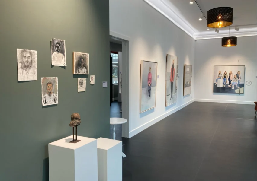 Interior de la Galería de Arte Besada en O Grove, con obras expuestas en las paredes y esculturas.